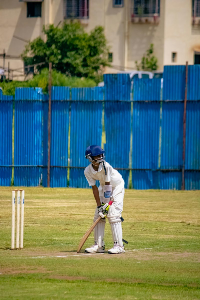 Young cricket player in white uniform ready to bat